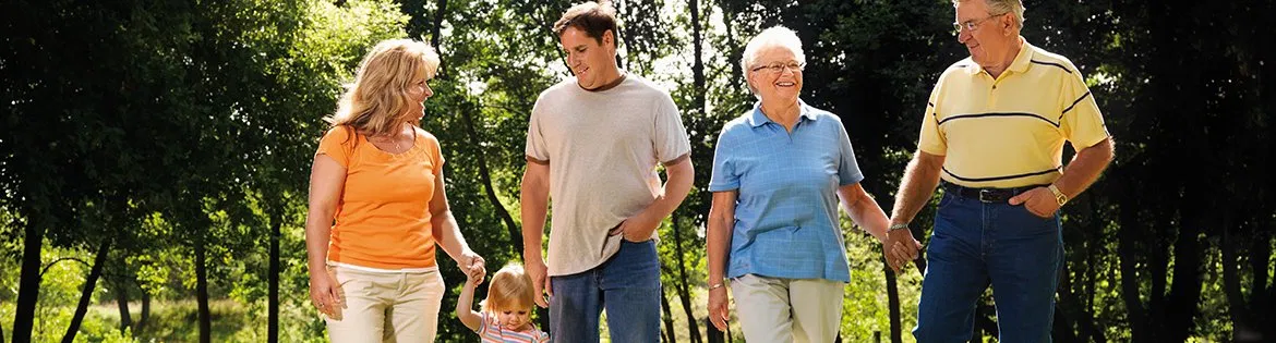 Three generations of a family walking together outdoors